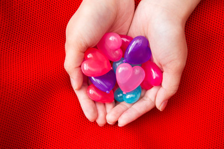 colorful hear shapes held by handsの写真素材