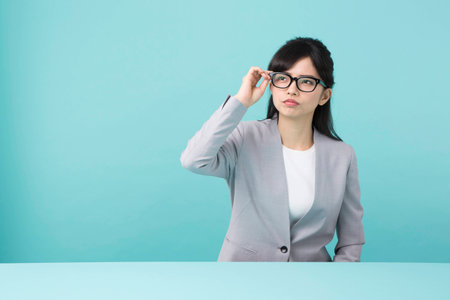 A woman with glasses put hand on the headの写真素材
