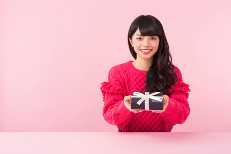 A woman holding a gift boxの写真素材