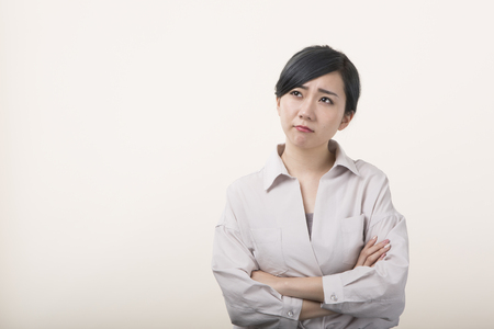 Young woman crossing arms with troubled faceの写真素材