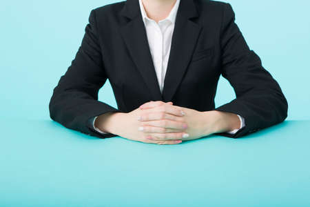 Woman's hand in a black suit assembled on a green tableの写真素材