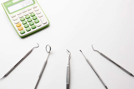 Dental treatment instruments and calculators placed on a white background