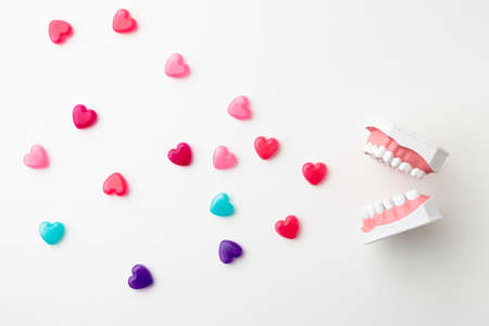 An oral model on a white background and a colorful heart-shaped capsuleの写真素材