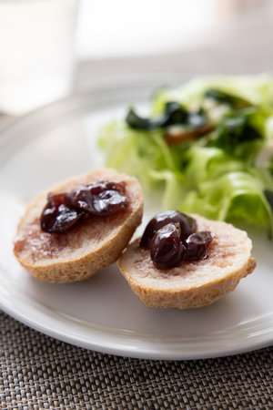 Slices of bread with grape jam with saladの写真素材