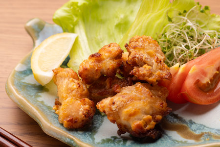 Japanese food, deep fried chicken wings on plate with salad and lemonの写真素材