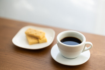 Coffee cup and saucer on wood table with window backgroundの写真素材