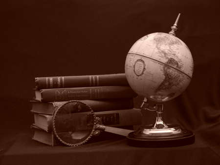 Globe with magnifying glass and booksの写真素材