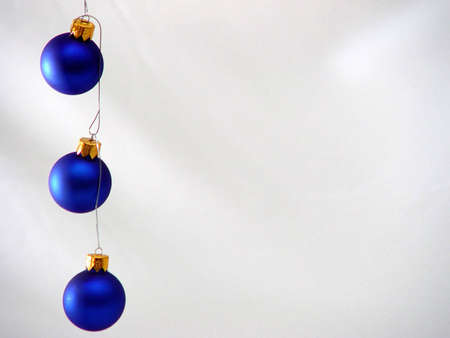 Blue colored Xmas ornaments against a snowy backgroundの写真素材