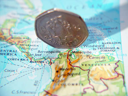 Dollar coin from Barbados placed over the area on an atlas.の写真素材