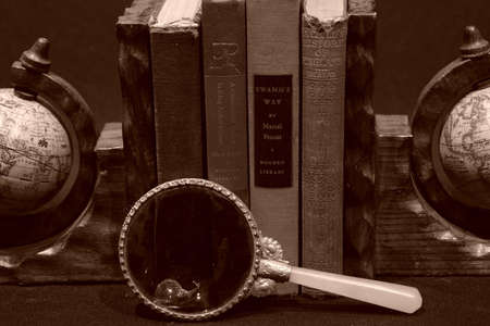 Photo of books with magnifying glass and candleの写真素材