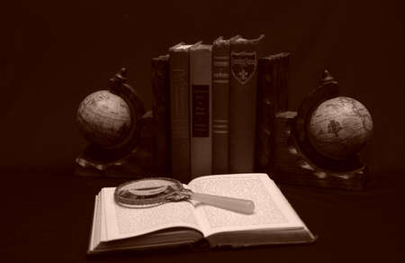 Photo of books with magnifying glass and candleの写真素材