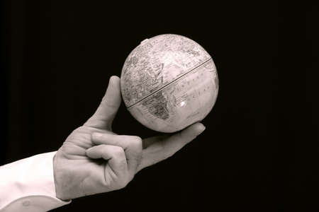 Man holding world globe with his fingertips.