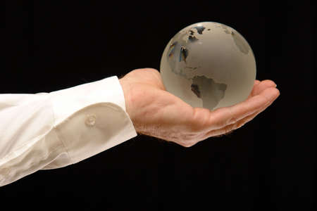 Man holding world globe with his fingertips.