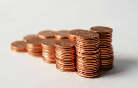 Stacks of pennies against a white backgroundの写真素材