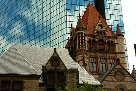 portion of the trinity church in boston with mirrored skyscraper in the backgroundの写真素材