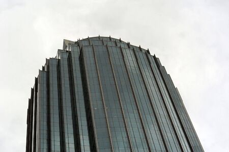unusual slightly curved modern skyscraper in boston against a cloud filled sky
