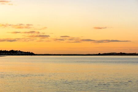 Sunset on Crane's beach in Ipswich Massachusetts with land in the backgroundの写真素材