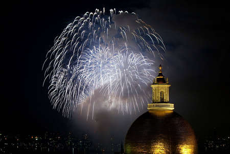 fourth of july fireworks explode in the sky over the charles river with the massachusetts state house in the foregroundの写真素材