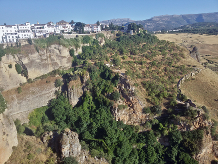 Green bushes on the rocky mountains in Ronda, Spainの写真素材