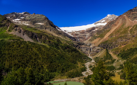 view on snowcapped mountains in the Bernina Range on the border of Switzerland and Italy from railway station Alp Grum, near St. Moritz, in summer. Grisons, Switzerland, Europeの写真素材