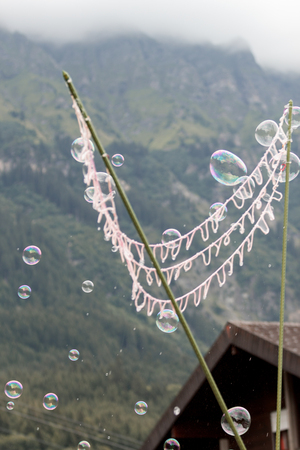 big net creating multiple soap bubbles on a mountain backgroundの写真素材