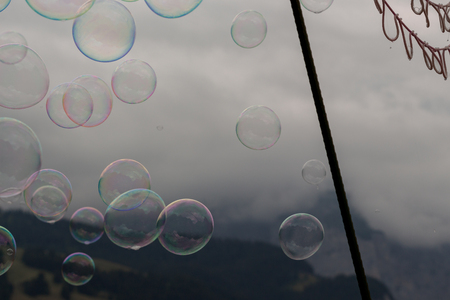 Multiple soap bubbles in the air with net on a foggy mountain backgroundの写真素材