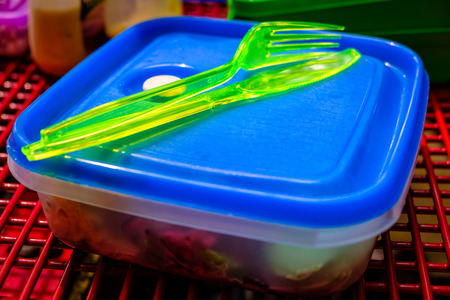 Plastic knife and fork on top of lunch box ready for picnicの写真素材