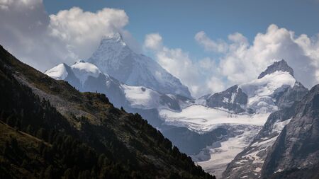 Snow capped mountain peaks of the Pointe de Zinal (3789m / 12431ft) and the famous Matterhorn (4478m / 14692ft) seen from Saint-Luc in the swiss canton Valais (Wallis)の写真素材