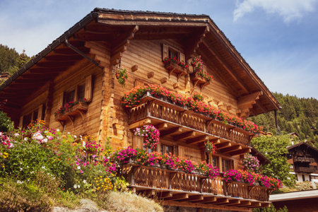 A beautiful wooden house decorated with flowers on the balconies in the Swiss alpine village Grimentz in the canton of Valais. Anniviers, Switzerlandのeditorial素材
