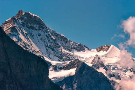 Summits of the majestic snow capped Jungfrau and Silberhorn on a summer day seen from Grindelwald Firstの写真素材