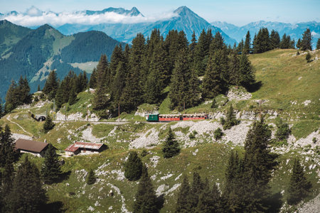 Schynige Platte, Interlaken, Switzerland - August 1 2019: Stunning view on mountain landscape in Bernese Oberland with picturesque tourist train climbing to Schynige Platte on sunny summer dayのeditorial素材