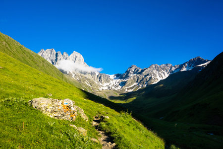 Light and shade in the mountain valley. In the background are the summits of Chauchiの写真素材