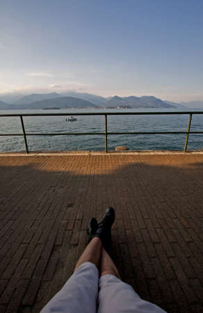 Man's Legs Relax on the shore of a lakeの写真素材