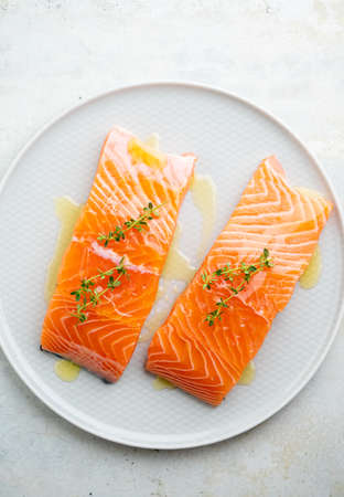 Fresh salmon fillet with herbs on a plate for delicious salmon steak.の写真素材