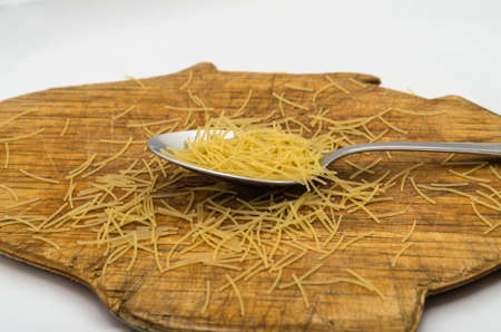 Photo spoon with pasta on a cutting board