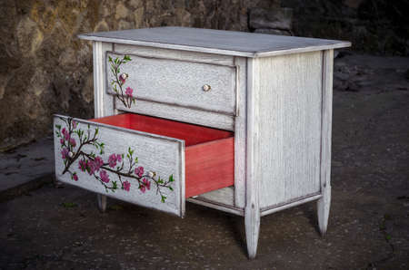Chest of drawers made of solid natural wood with artistic paintingの写真素材