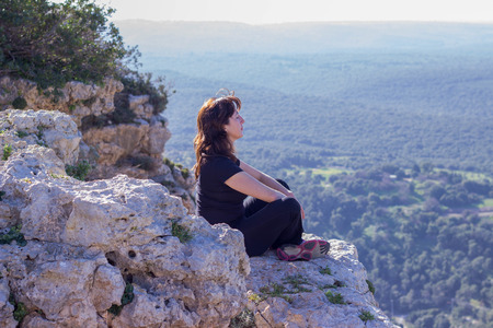woman in a black tracksuit sitting on the cliff and meditatesの写真素材