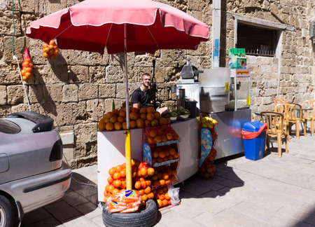 Acre, Israel - May 28, 2016: Street vendor of fresh fruit, fresh juice and popcorn awaiting buyers in old city, in Akre, Israelのeditorial素材