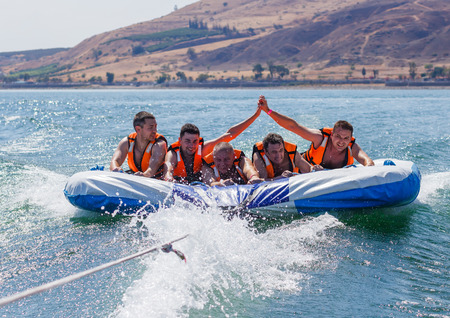 Tiberias, Israel, September 27, 2016: Group of young men floating on an inflatable attraction on Lake Kinneret in Tiberias, Israelのeditorial素材