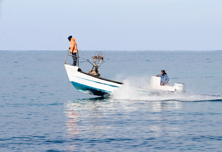 Nahariyya, Israel - February 04, 2017 : Fishermen in overcast weather patrol on boat and looking for fish near the shore of Nahariyya, Israelのeditorial素材
