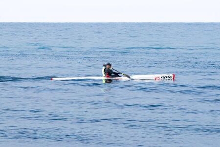 Nahariyya, Israel - February 04, 2017 : Athlete in color tracksuit  training on kayak winter morning on Mediterranean Sea near the coast of Nahariyya, Israelのeditorial素材