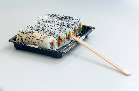 Portion of several kinds of sushi on a tray and chopsticksの写真素材