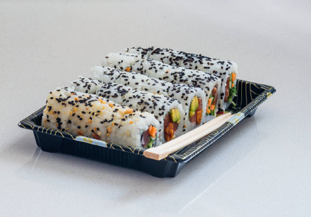 Portion of several kinds of sushi on a tray and chopsticksの写真素材