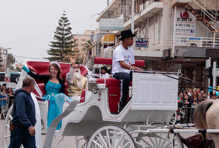 Nahariyya, Israel, March 10, 2017: Dressed in costumes participants of traditional annual Ñarnival parade "Adloyada" ride in an open carriage along the street and waved their hands to the viewers in Nahariyya, Israelのeditorial素材