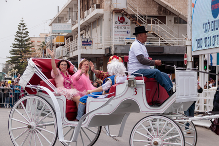 Nahariyya, Israel, March 10, 2017: Dressed in costumes participants of traditional annual Ñarnival parade "Adloyada" ride in an open carriage along the street and waved their hands to the viewers in Nahariyya, Israelのeditorial素材