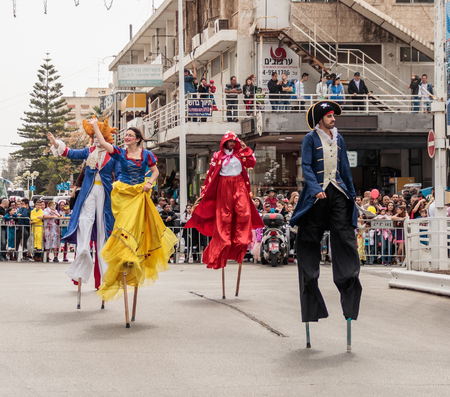 Nahariyya, Israel, March 10, 2017 : Participants at the traditional annual carnival parade "Adloyada" dressed in special costumes on stilts are walking along the street in Nahariyya, Israelのeditorial素材