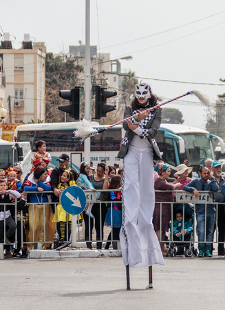 Nahariyya, Israel, March 10, 2017 : Participants at the traditional annual carnival parade "Adloyada" dressed in special costumes on stilts are walking along the street in Nahariyya, Israelのeditorial素材