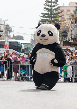 Nahariyya, Israel, March 10, 2017 : Participant in the traditional annual carnival parade "Adloyada" dressed in the big suit of Panda goes near the viewers in Nahariyya, Israelのeditorial素材