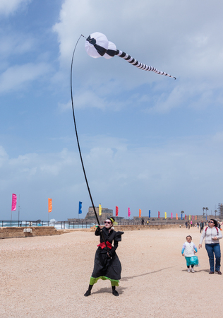 Caesarea, Israel, March 11, 2017 : Participants of the Purim festival dressed in costumes of clowns show a show with kites in Caesarea, Israelのeditorial素材