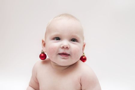 Little baby girl with christmas edcorations as earringsの写真素材